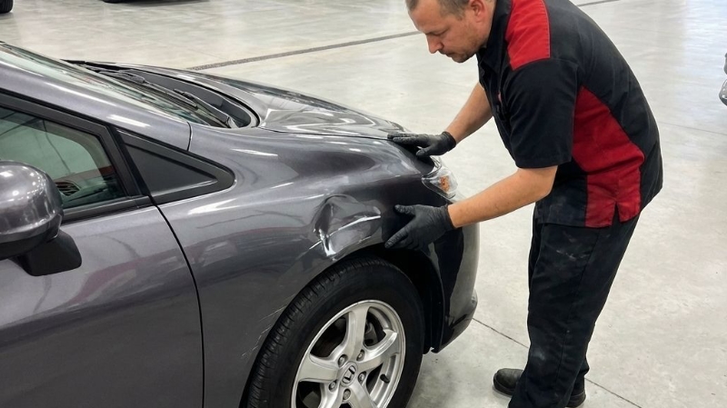 I-Car Certified Collision Center tech inspecting damage