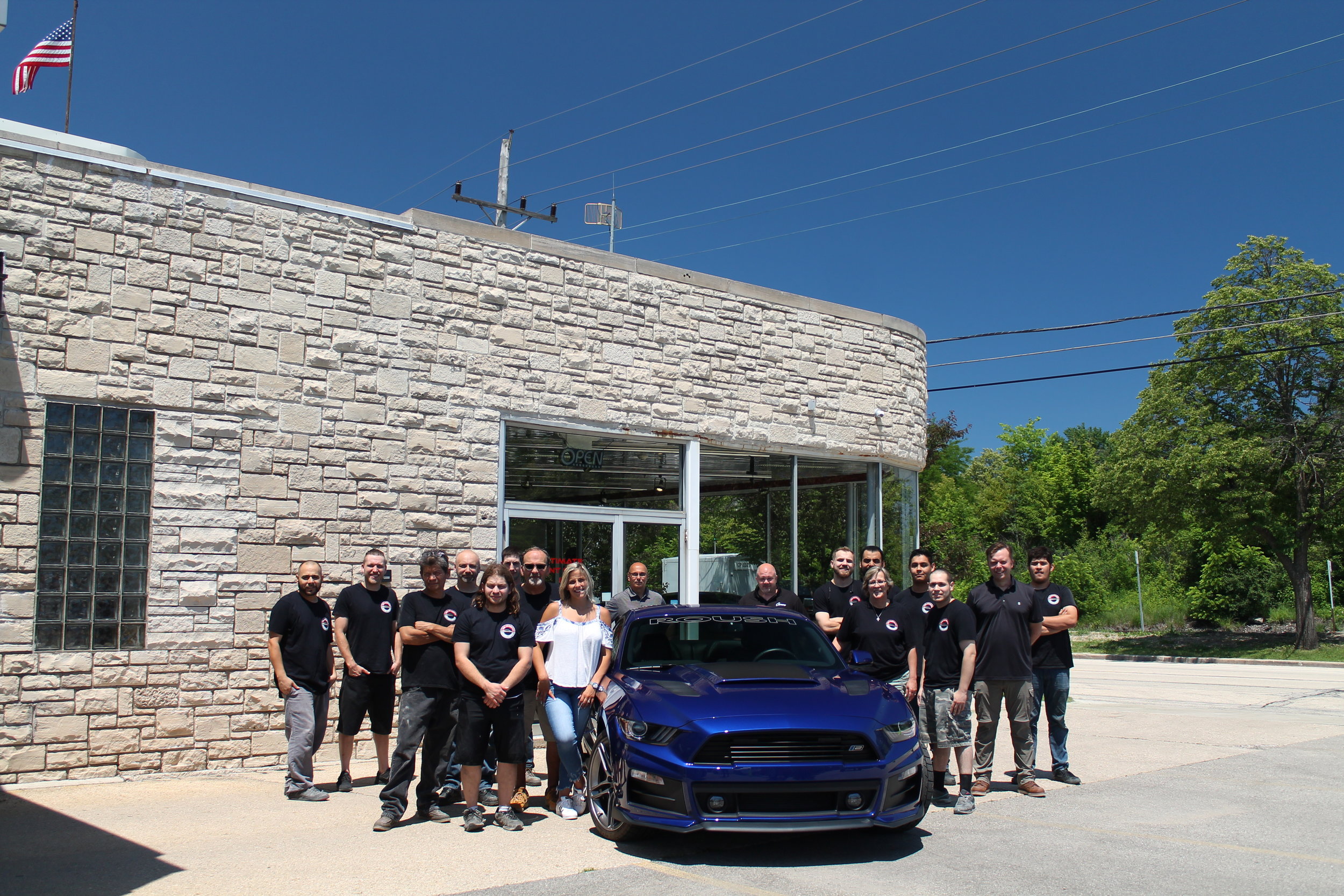 Highland Park Ultimate Paint Shop Body Shop team around blue mustang 